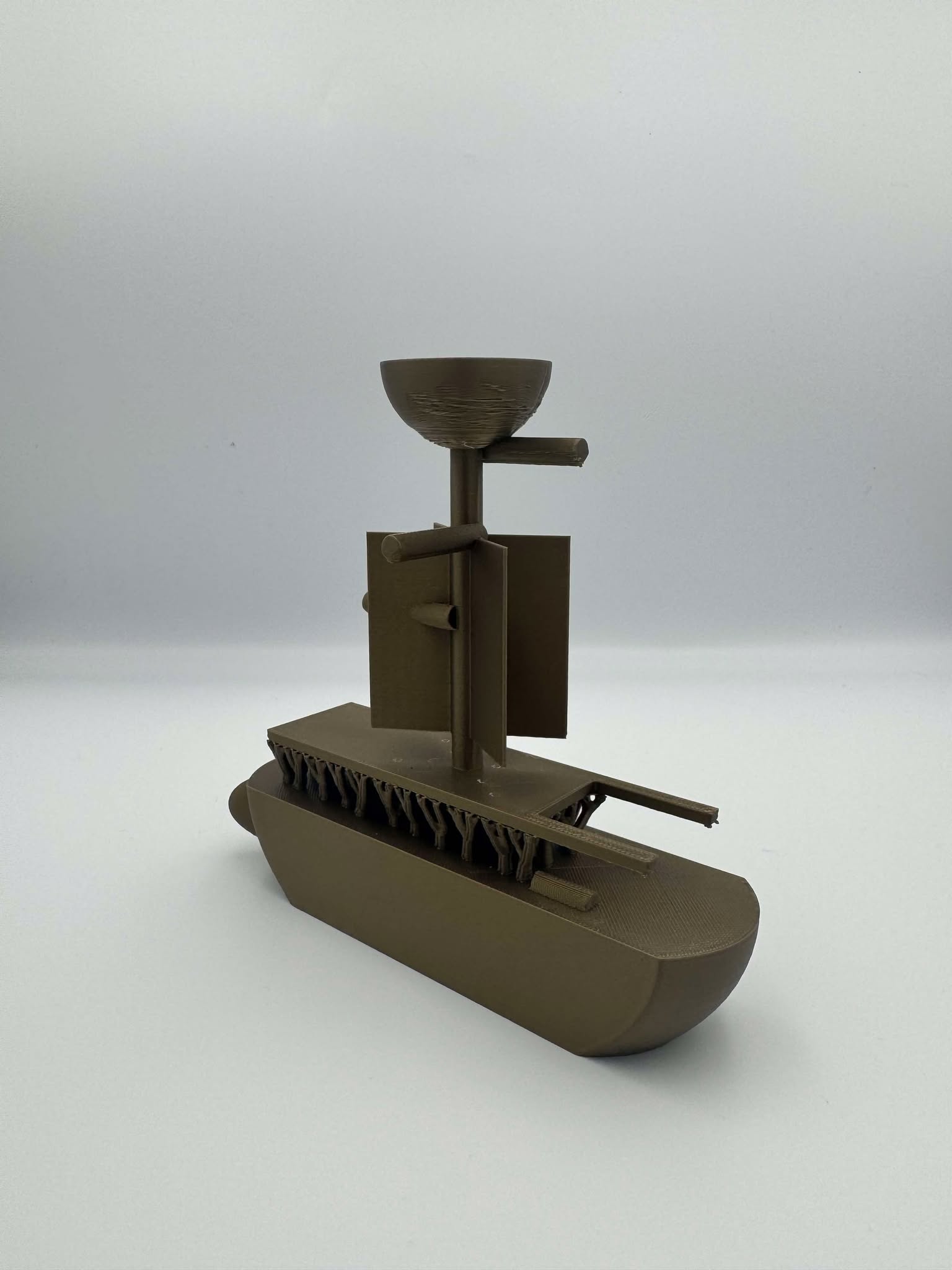Jewelry holder ship This image depicts a 3D-printed model of a boat-like structure in a metallic gold-like color.