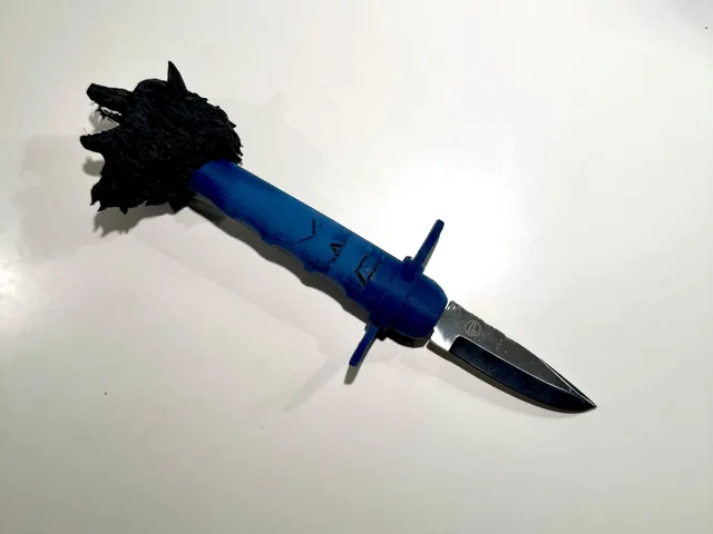 Skæftet er et langt cylindrisk greb med runer indgraveret langs siden. I den ene ende er der et stort detaljeret ulvehoved med pelsstruktur, ører, snude og åben mund. Nær den anden ende strækker to buede beskyttelsesformer sig udad som kløer.