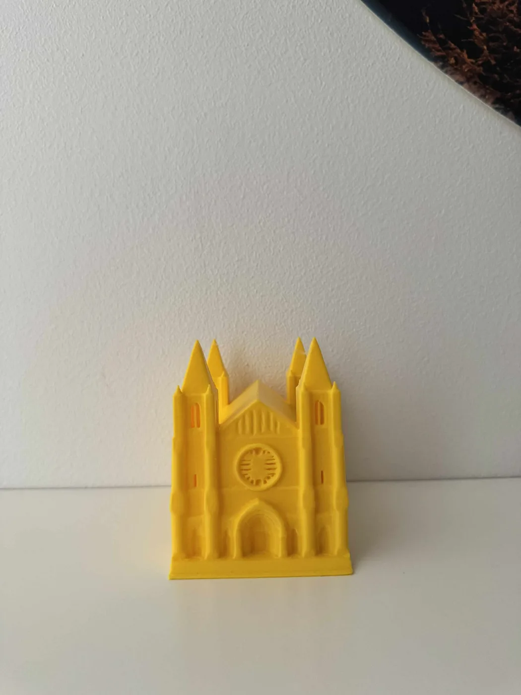 Nærbillede af den 3D-printede punktskrift-katedral i gylden-gul PLA, set op mod de to spirtårne og fialer, med et felt af hævede punktskriftpunkter præget tværs over den nederste facade, klar til at læse med fingrene